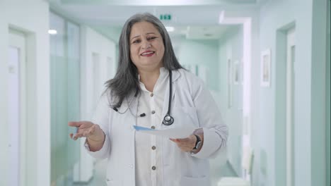 Happy-Indian-senior-female-doctor-explaining-reports-to-patient