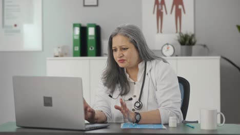 Happy-Indian-female-senior-doctor-talking-to-patient-on-video-call