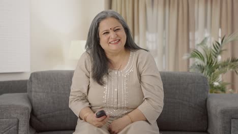 Happy-Indian-old-woman-watching-TV-and-laughing