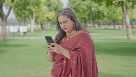 Angry-Indian-old-woman-chatting-on-phone-in-park