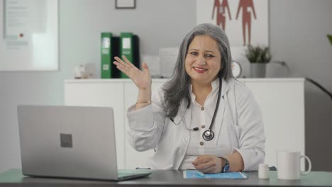 Happy-Indian-senior-female-doctor-waving-and-saying-Hello