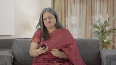 Angry-Indian-old-woman-trying-to-fix-TV-remote