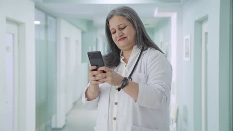 Happy-Indian-senior-female-doctor-chatting-on-phone