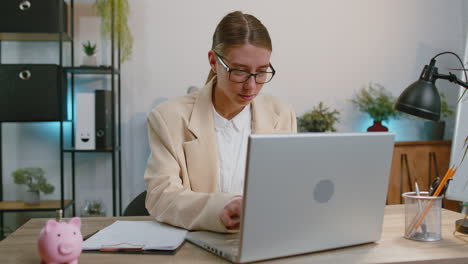 Glückliche-Geschäftsfrau,-Die-Am-Laptop-Im-Büro-Arbeitet-Und-Sich-über-Den-Gewinn-Freut,-Geld-In-Bar-Zu-Erhalten,-Erfolg-Im-Lotto