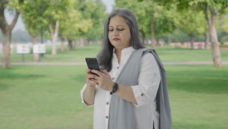 Feliz-Madre-India-Charlando-Por-Teléfono-En-El-Parque