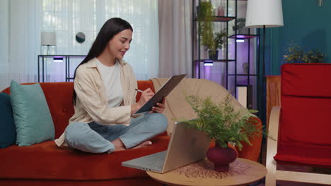 Young-businesswoman-working-with-laptop-computer-and-documents,-planning-expenses-budget-at-home