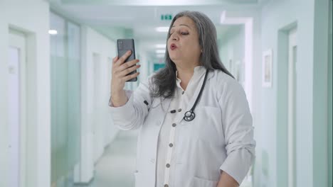 Happy-Indian-senior-female-doctor-talking-on-video-call