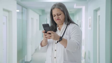 Angry-Indian-senior-female-doctor-chatting-on-phone