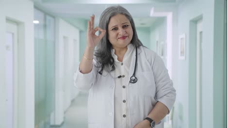 Happy-Indian-senior-female-doctor-showing-okay-sign