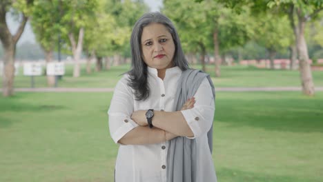 Confident-Indian-mother-standing-crossed-hands-in-park