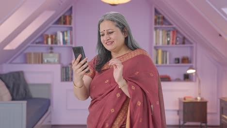 Happy-Indian-old-woman-scrolling-through-phone