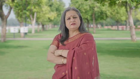 Portrait-of-Confident-Indian-old-woman-standing-crossed-hands-in-park