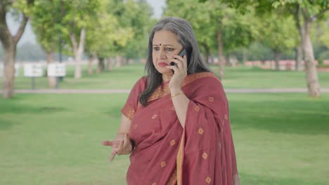 Indian-old-woman-talking-on-phone-in-park