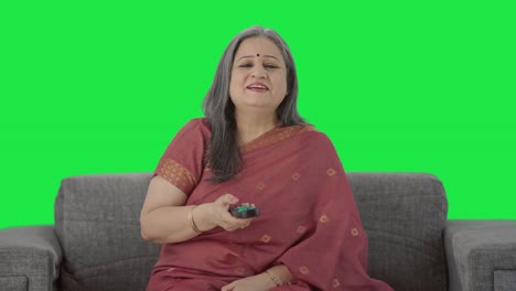 Cheerful-Indian-old-woman-watching-TV-Green-screen