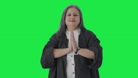 Happy-Indian-senior-female-lawyer-doing-greetings-and-Namaste-Green-screen