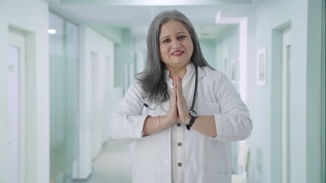 Happy-Indian-senior-female-doctor-greeting-and-doing-Namaste