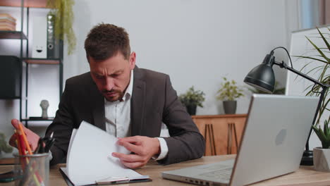 Un-Hombre-De-Negocios-Enojado-E-Irritado-Trabajando-En-Una-Computadora-Portátil-Analizando-La-Disminución-Del-Gráfico-Financiero,-Rompiendo-Un-Lápiz