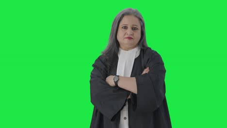 Indian-senior-female-lawyer-standing-crossed-hands-Green-screen