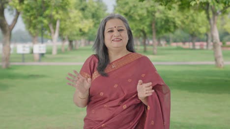 Happy-Indian-old-woman-talking-to-the-camera-in-park