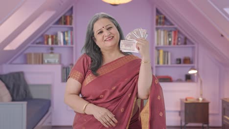 Happy-Indian-old-woman-using-money-as-fan