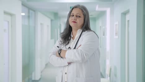 Portrait-of-Confident-Indian-senior-female-doctor-standing-crossed-hands