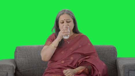 Happy-Indian-old-woman-taking-medicine-Green-screen