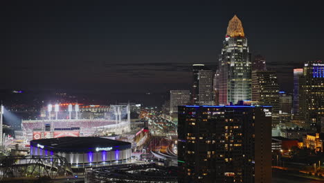 Vuelo-Aéreo-V38-Sobre-El-Río-En-Cincinnati,-Ohio,-Que-Captura-El-Estadio-Y-El-Estadio-De-Béisbol-Frente-Al-Río,-El-Paisaje-Urbano-Nocturno-Iluminado-Del-Centro-De-Entretenimiento-Y-Negocios;-Filmado-Con-Inspire-3-8k---Septiembre-De-2023