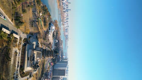 Vertical-aerial-view-of-downtown-Linyi-in-Shandong-Province,-China-with-the-Benghe-River-and-Art-Museum-in-the-background-of-the-city-skyline