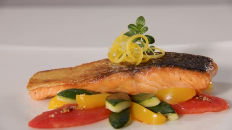 Gourmet-salmon-fillet-perfectly-seared,-served-with-colorful-zucchini-and-tomato,-garnished-with-lemon-zest