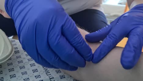 close-up-of-nurse-removing-needle-from-vein-and-taking-care-of-patient