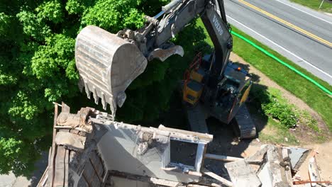 Working-Excavator-demolishing-destroyed-house-after-hurricane-in-USA