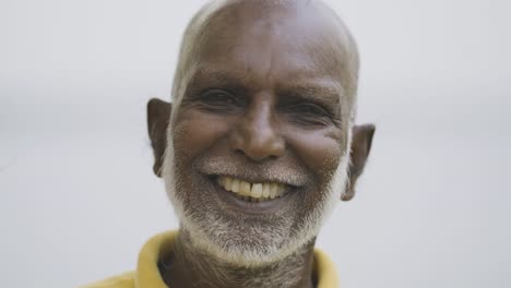 Elderly-man-with-a-white-beard-smiling-and-laughing,-outdoors-in-Sri-Lanka