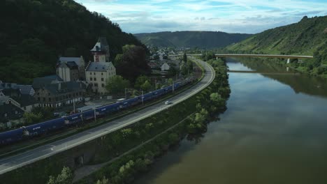 Zwei-Lokomotiven-Mit-Kohlewaggons-Fahren-Mit-Hoher-Geschwindigkeit-Entlang-Der-Mosel-In-Deutschland