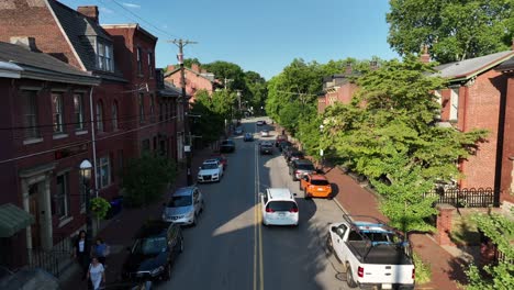 Langsamer-Drohnenflug-über-Die-Straße-Im-Amerikanischen-Viertel-Mit-Fahrenden-Autos-Im-Sommer