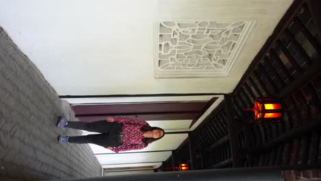 Woman-walking-through-corridor-with-traditional-Chinese-design