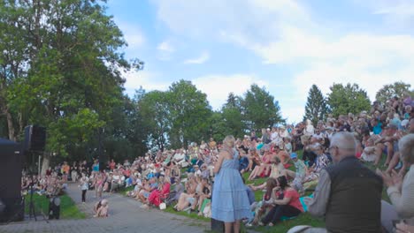 Personas-Aplaudiendo-En-Un-Concierto-O-Espectáculo-En-Un-Festival-Después-De-Que-La-Actuación-Haya-Terminado-Durante-Un-Hermoso-Día-De-Verano-En-Tallin,-Estonia,-Con-Un-Cielo-Azul-Con-Ligeras-Nubes-Visibles-En-Cámara-Lenta-Y-4k.