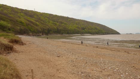 View-of-Sand-Bay-Beach-with-few-people-loitering-around-in-Weston-super-Mare,-England