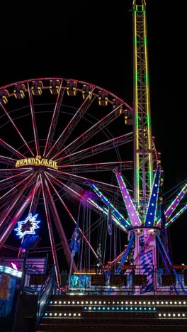 Vertical,-Night-Time-lapse-of-Illuminated-Funfair-Rides-at-Amusement-Park,-Motion-Blur