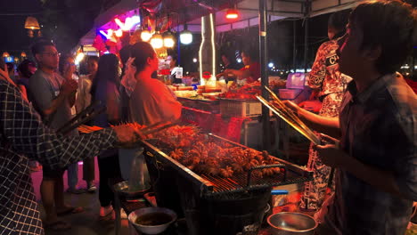 Zwei-Köche-Grillen-Baby-Oktopus-Auf-Einem-Asiatischen-Nachtmarkt,-Tiefer-Fokus