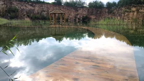 Pasarela-De-Madera-En-Un-Lago-Con-Peces-Nadando-En-El-Parque-Grodek-En-Jaworzno,-Polonia