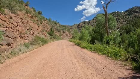 POV---Driving-on-gravel-road-guard-rails-with-steep-granite-embankments-in-Rocky-Mountain-Front-Range-in-Colorado