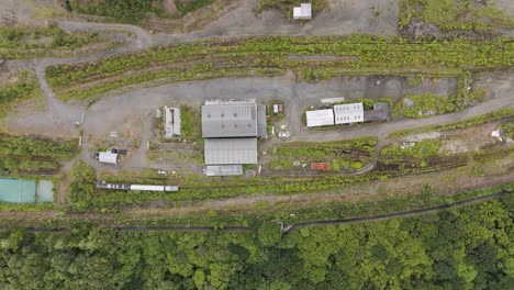 Aerial-top-down-view-of-a-disused-industrial-railway-in-an-abandoned-quarry-overgrown-with-vegetation