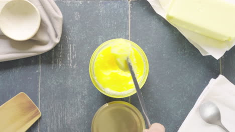 Pouring-ghee-butter-into-a-pot-with-a-knife