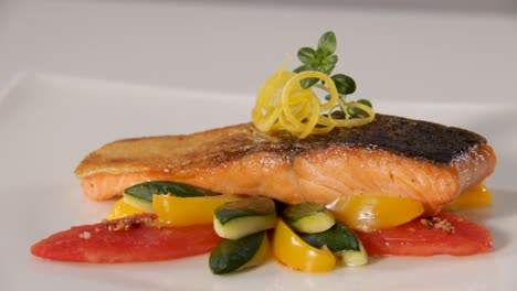 Pan-seared-salmon-fillet-with-crispy-skin,-served-with-fresh-zucchini,-bell-peppers,-and-garnished-with-lemon-zest