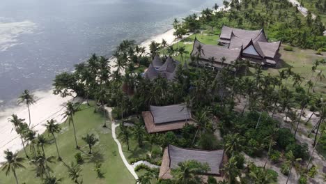 Resort-De-Lujo-En-Una-Isla-De-Estilo-Tribal-En-Una-Playa-Tropical-De-Arena-Blanca,-Vista-Con-Drones