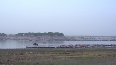 Pilgrims-at-sacred-Hindu-religious-site-Triveni-Sangam-in-summer-evening,-the-confluence-of-the-Ganges-and-the-Yamuna-rivers-in-Prayagraj,-Uttar-Pradesh