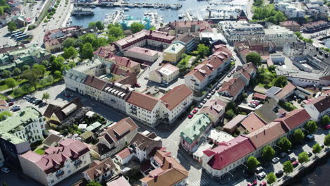 Strömstad-marina-in-summer-showcasing-colorful-rooftops-and-boats-in-the-harbor,-aerial-view