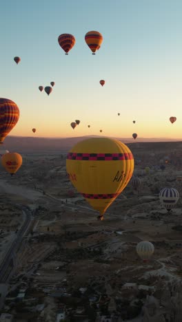 Vertical-Aerial-View-of-Hot-Air-Balloons-Above-Fairytale-Landscape-of-Cappadocia,-Turkey-on-Sunny-Morning