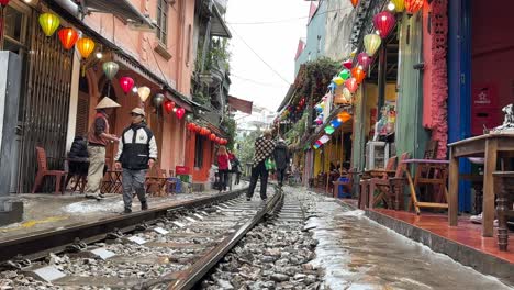 Vista-Aérea-De-La-Calle-Del-Tren-De-Hanoi,-Vietnam,-Toma-Baja,-Gente-En-Las-Vías---Los-10-Mejores-Destinos-Turísticos