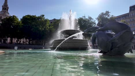 Stunning-view-of-the-Trafalgar-Square-fountain-in-London-on-a-bright-sunny-morning,-showcasing-the-vibrant-water-display